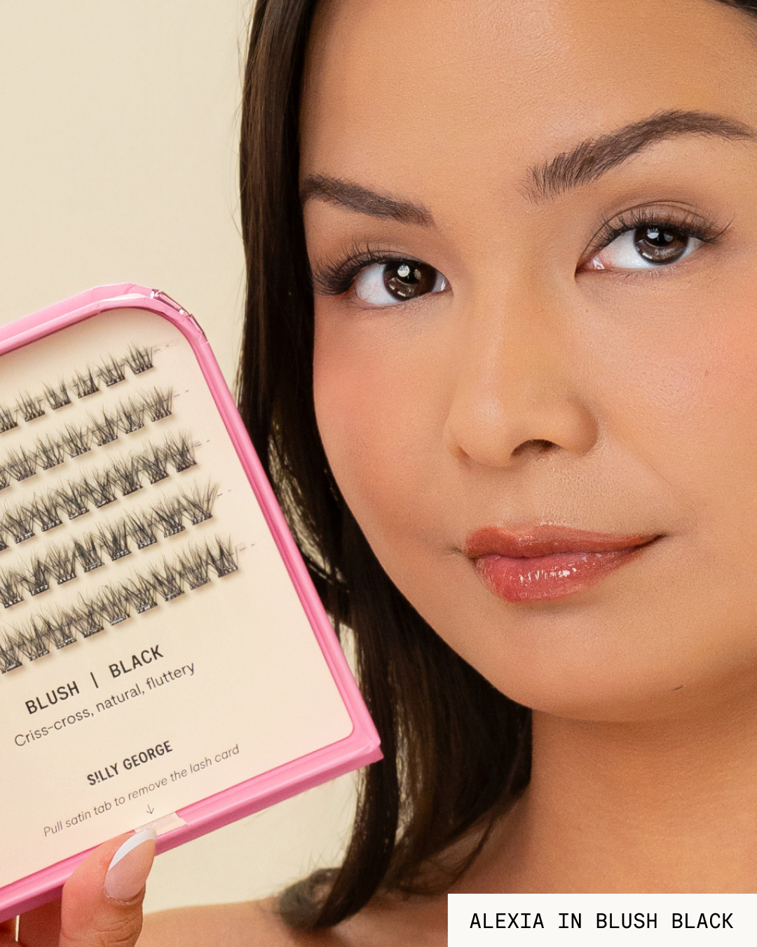 Model Alexia holding a pink package of black Blush Pop-On Lashes: The Extensions Set