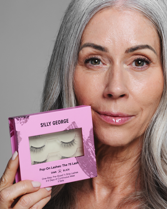 Model Jill holding a pink package of black Dawn Pop-On Lashes: The 75 Lash