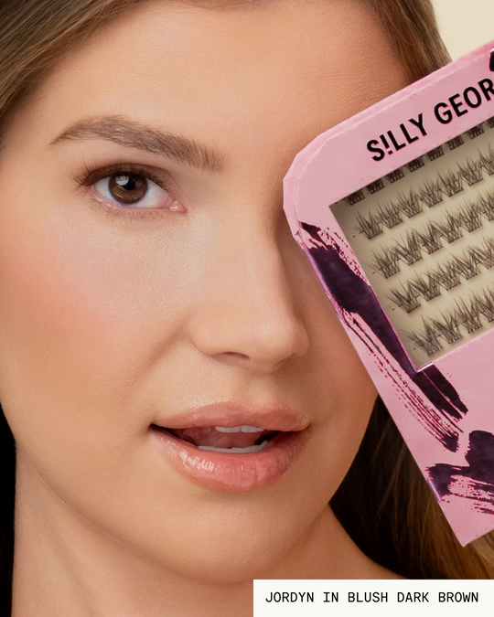 Model Jordyn holding a pink package of dark brown Blush Pop-On Lashes: The Extension Set