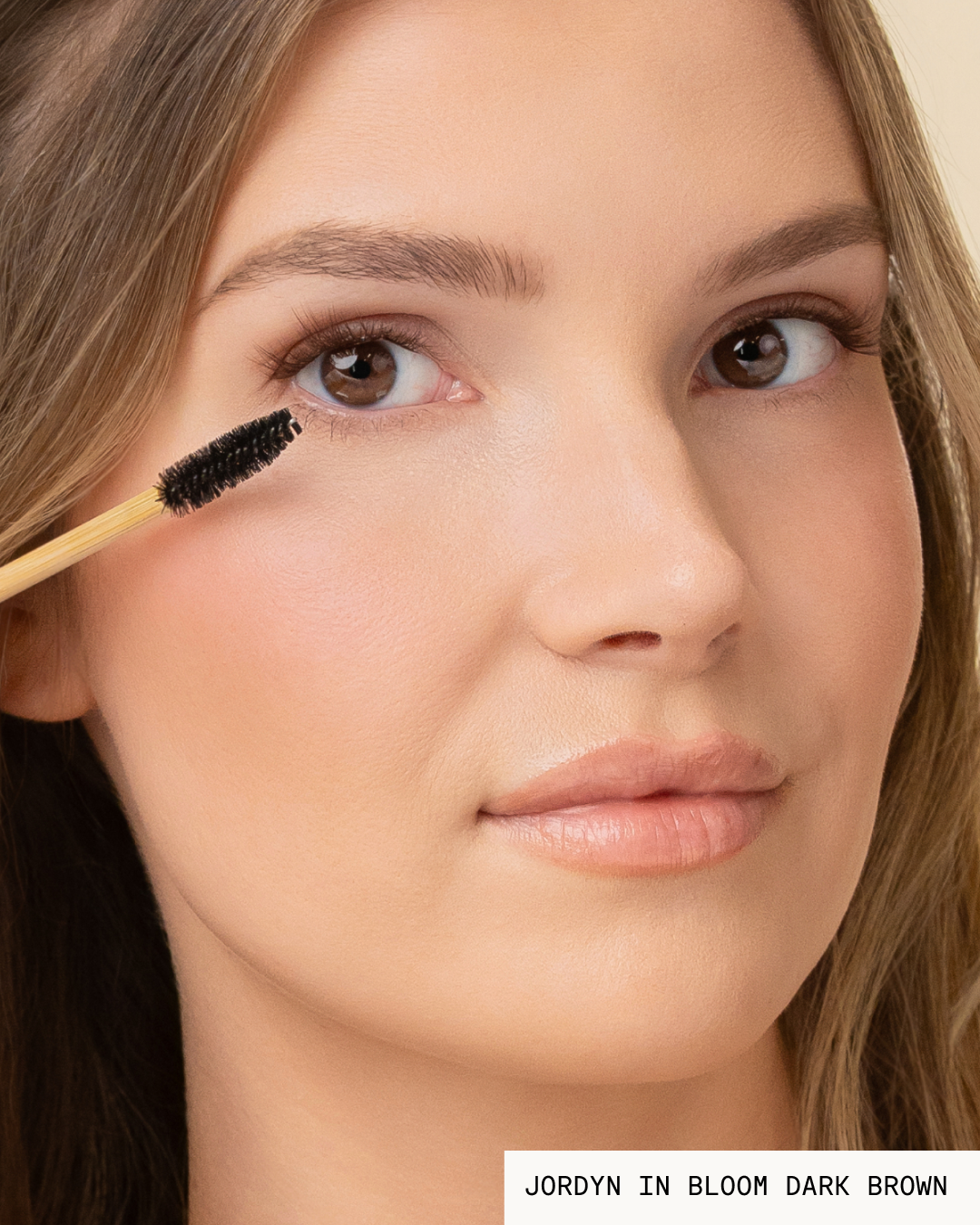 Model Jordyn brushing Bloom Pop-On Lashes: The Extensions Set in dark brown