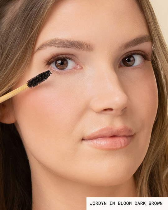 Model Jordyn brushing Bloom Pop-On Lashes: The Extensions Set in dark brown