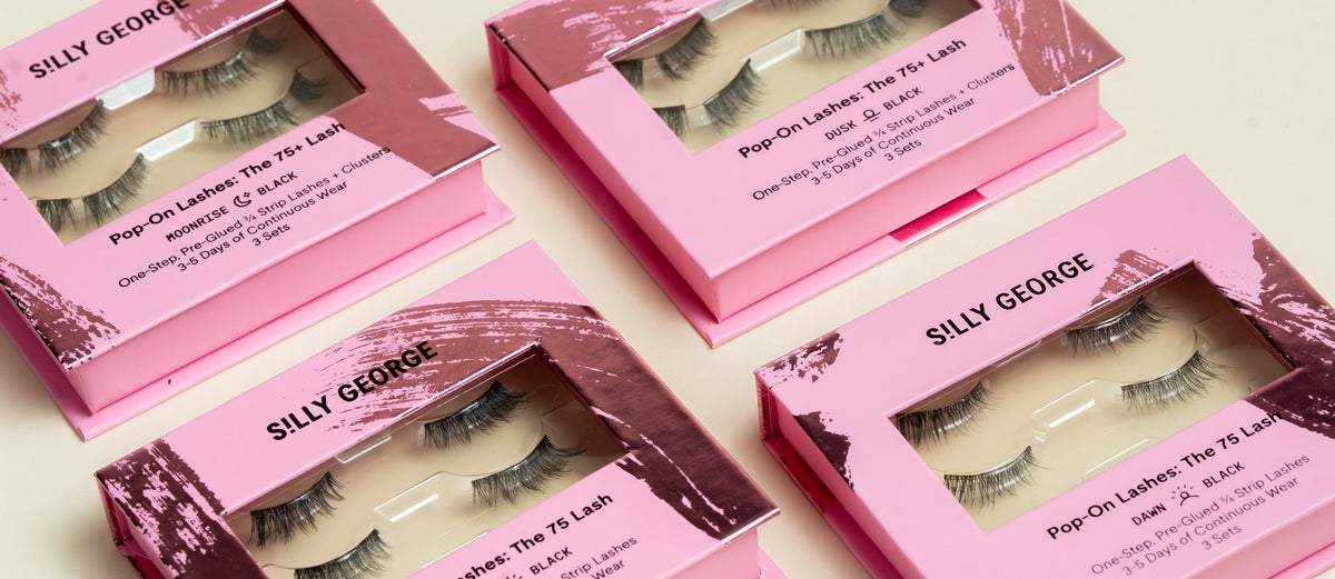 Multiple boxes of Silly George false eyelashes on a light background