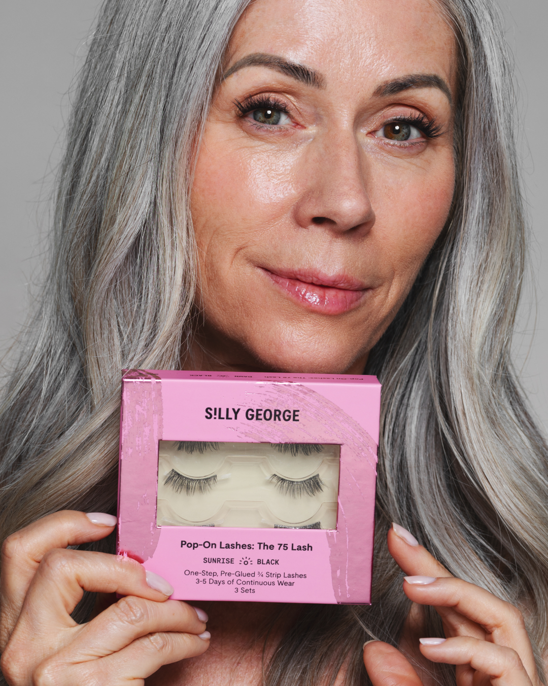 Woman holding a package of black Sunrise Pop-On Lashes: The 75 Lash