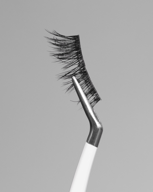 Close up of Sunrise Pop-On Lashes: The 75 Lash held with tweezers