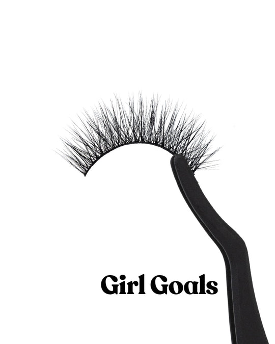 Black false eyelashes with 'Girl Goals' text on a white background