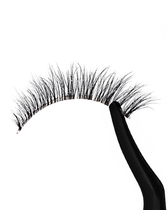 False eyelashes with a black holder on a white background