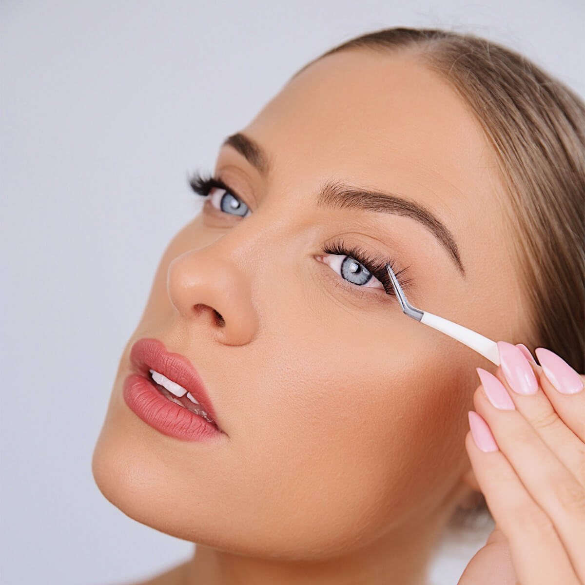 a woman applying false eyelashes 